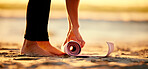 Hands, beach and woman roll yoga mat getting ready for workout, exercise or stretching. Zen, meditation and feet of female yogi outdoors on seashore while preparing for chakra training and pilates.