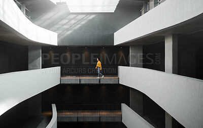 Buy stock photo Architecture, lighting and walking woman in a building for work, entrepreneurship and start of job. Design, professional and designer on a walk in the corridor of an elegant and modern workplace