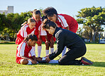 Accident, injury and children soccer team with their coach in a huddle helping a girl athlete. Sports, training and kid with a sore, pain or muscle sprain after a match on an outdoor football field.