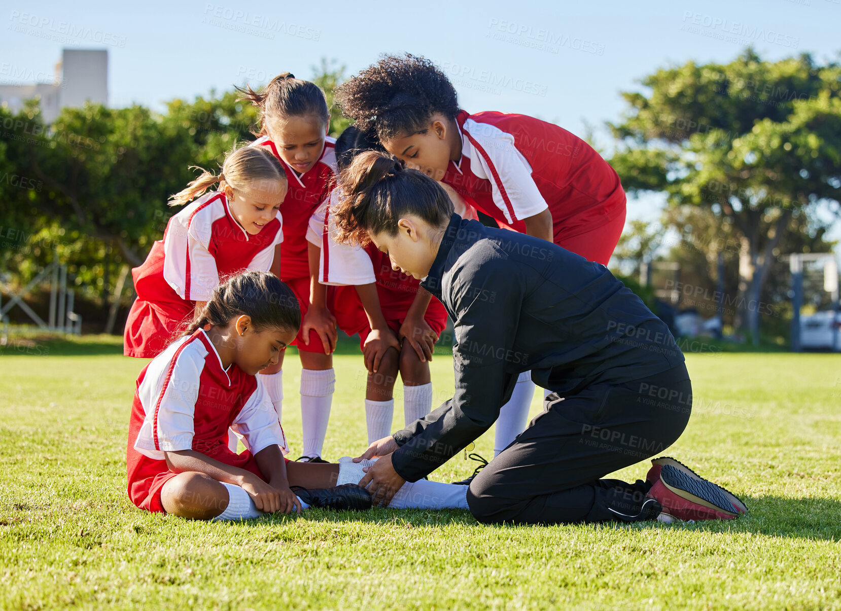 Buy stock photo Accident, injury and children soccer team with their coach in a huddle helping a girl athlete. Sports, first aid and kid with a sore, pain or muscle sprain after a match on an outdoor football field.