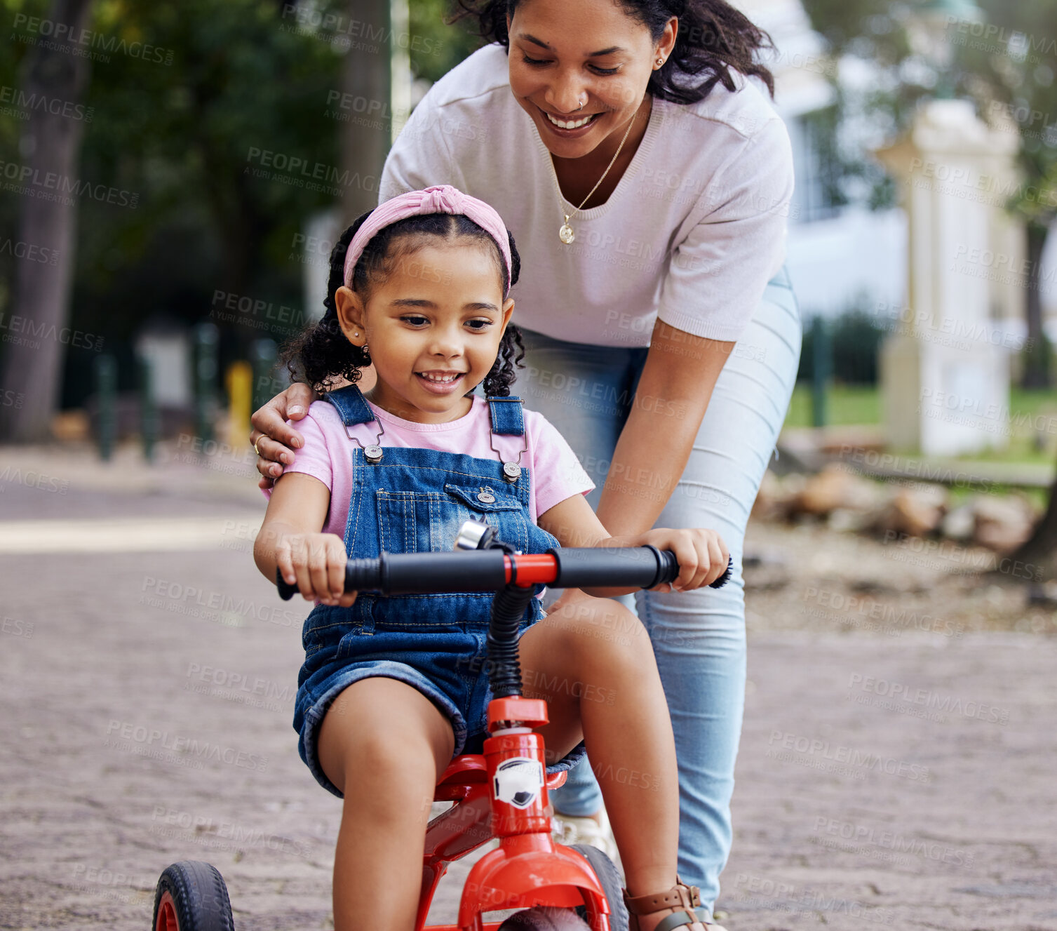 Buy stock photo Mother, child and bicycle teaching with training wheels for learning or practice at the park. Happy mom helping little girl to ride her first bike with smile for proud playful moments in the outdoors