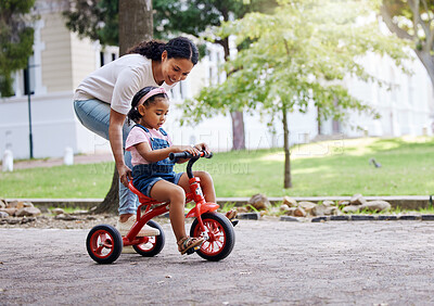 Buy stock photo Mother teaching child, bike and learning in park, outdoor with growth and development, family and care. Nature, learn to ride tricycle with woman and girl, childhood and parenting with happy female