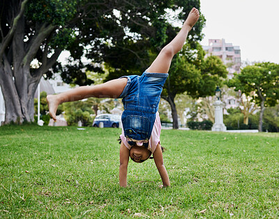 Buy stock photo Cartwheel, child and outdoor park fun of a girl in summer with freedom and happiness. Fun, happy and holiday play of a young kid on green grass in nature on a morning with blue sky and smiling