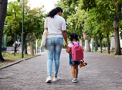 Buy stock photo Mother, child and walking with backpack holding hands to school for safety at the outdoor park. Mom with little girl or daughter having a walk together for safe travel, trip or care for childhood