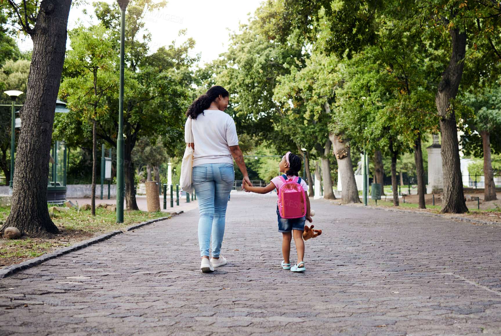 Buy stock photo Walking, park and mother holding hands with girl on journey for back to school, learning and class for first day. Love, black family and mom with child walk for kindergarten, education and play date