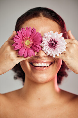 Buy stock photo Woman, face and flower eyes with smile for natural skincare, beauty or cosmetics isolated on a grey background. Happy female, person or lady smiling in happiness holding colorful plant petals for art