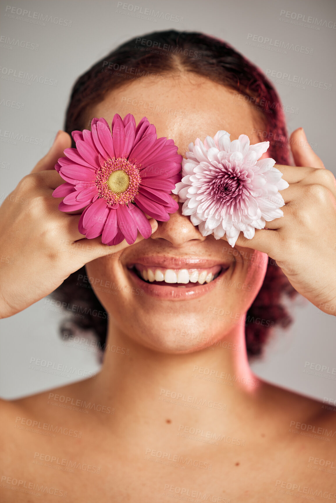 Buy stock photo Woman, face and flower eyes with smile for natural skincare, beauty or cosmetics isolated on a grey background. Happy female, person or lady smiling in happiness holding colorful plant petals for art