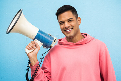 Buy stock photo Megaphone, man and portrait of a male speaker ready for justice, equality and human rights speech. Smile, happiness and isolated blue background in a studio smiling and excited about social change