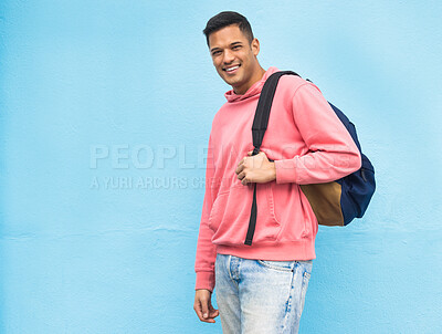 Buy stock photo Portrait, university and man student with backpack in studio, happy and smile on blue background. Face, handsome and college student excited about education, vision and career goal while isolated