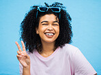 Black woman, happy smile and peace sign portrait of a model isolated with blue background in a studio. Young, smiling and v hand gesture of a person feeling relax with happiness with casual style
