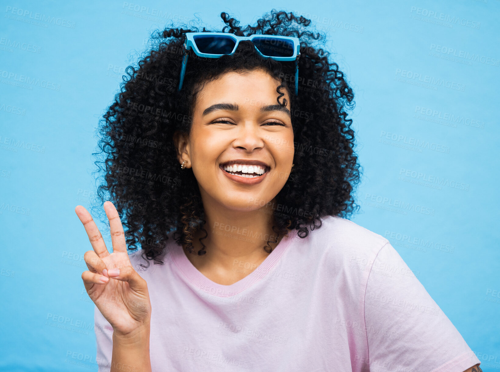 Buy stock photo Black woman, happy smile and peace sign portrait of a model isolated with blue background in a studio. Young, smiling and v hand gesture of a person feeling relax with happiness with casual style