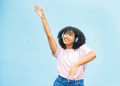 Buy stock photo Wall, black woman and dance with smile, celebration and relax on blue studio background. African American female, lady and dancing with headphones, movement and excited with casual outfit on backdrop