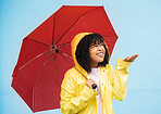 Black woman, umbrella or hand checking for rain on isolated blue background in Brazil city. Person, anxiety or student in weather water drops or rainfall with curious or wondering facial expression