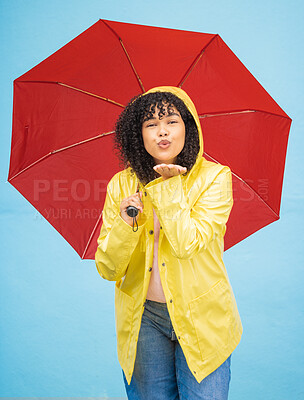 Buy stock photo Portrait, black woman and umbrella in a city for kiss, travel and flirting on a solo trip against wall background. Face, blowing kiss and girl traveler relax in rainfall, excited and emoji gesture 