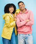 Couple of friends, portrait or bonding on isolated blue background in fashion, trend or cool style clothes. Smile, happy man or black woman with afro hair, arms crossed or weather raincoat protection