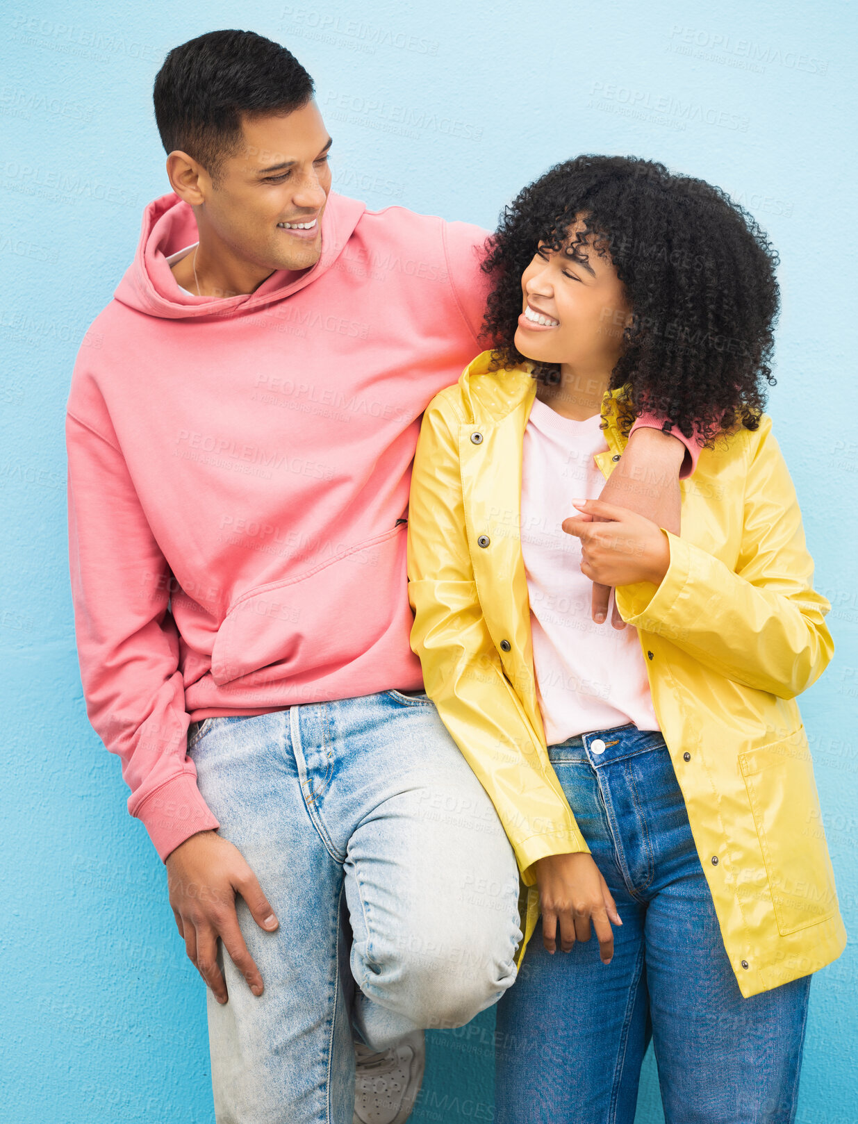 Buy stock photo Couple of friends, bonding and hug on isolated blue background in fashion, afro hair trend and cool style clothes. Smile, happy man and black woman in embrace on wall mock up backdrop in Brazil
