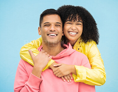 Buy stock photo Couple, smile and hug in portrait with happiness, love and commitment with fashion isolated on blue background. Interracial relationship, commitment and together in studio with happy people and trust