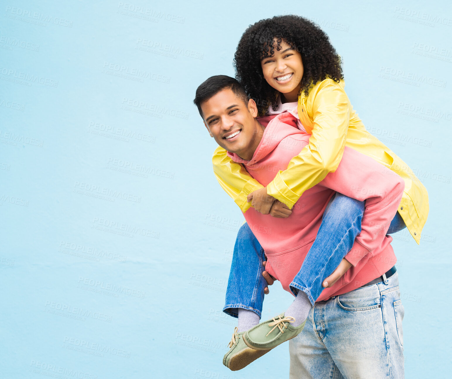 Buy stock photo Happy couple, bonding or piggyback portrait on isolated blue background in city travel, date or fun game. Smile, happy man or carrying black woman in silly, goofy or playful trust, support or love