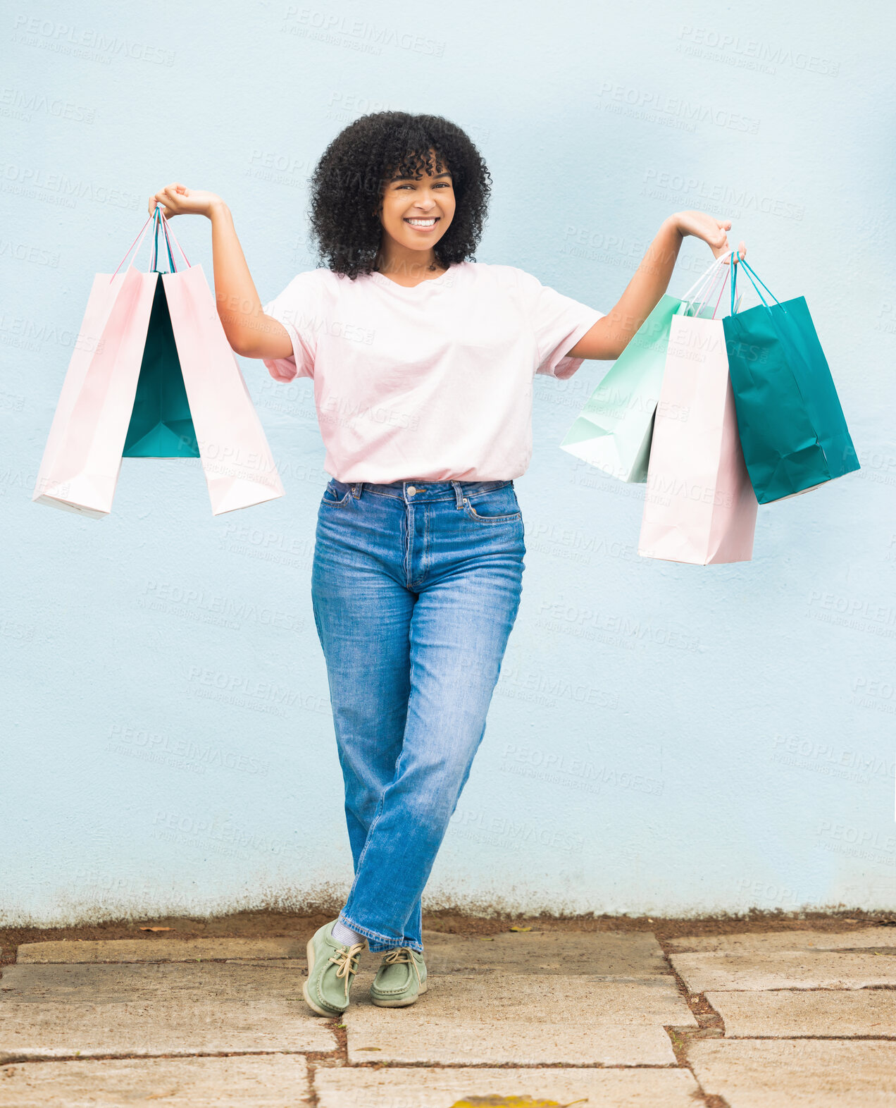 Buy stock photo Shopping, excited and portrait of a woman with bags from a sale on a blue city wall in Greece. Fashion, product and girl shopper carrying content from a shop, boutique or store downtown with a smile