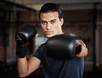 Portrait, fitness and workout with a boxer man training for a fight or competition in a gym for sports. Health, exercise and power with a young male athlete boxing in an mma or self defense club