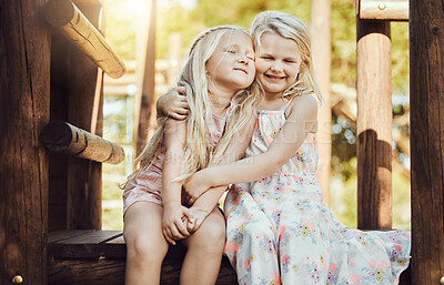 Buy stock photo Happy, hug and girl siblings at playground for bonding, wellness and outdoor summer fun together. Care, freedom and happiness of young kids embracing with cheerful smile at park in Canada.


