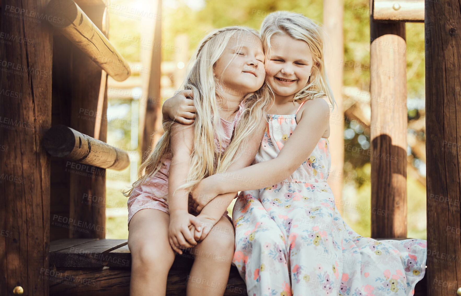 Buy stock photo Happy, hug and girl siblings at playground for bonding, wellness and outdoor summer fun together. Care, freedom and happiness of young kids embracing with cheerful smile at park in Canada.

