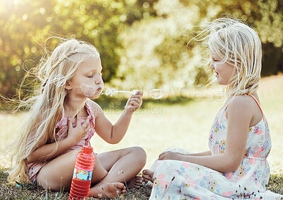Buy stock photo Nature, girls and friends blowing bubbles in a green garden being playful, happy and fun together. Happiness, holiday and sisters playing on the grass in an outdoor park in summer in Australia.