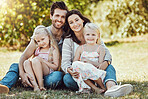 Family, garden and portrait of parents, children and happy people on park grass in sunshine. Kids, mom and dad smile with love in nature, holiday and summer vacation to relax on park lawn with peace