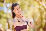 Woman runner, smartwatch and heart rate in nature park for fitness, health or wellness by trees. Outdoor training, running and digital tech in forest for anatomy, goal or healthcare at hiking workout