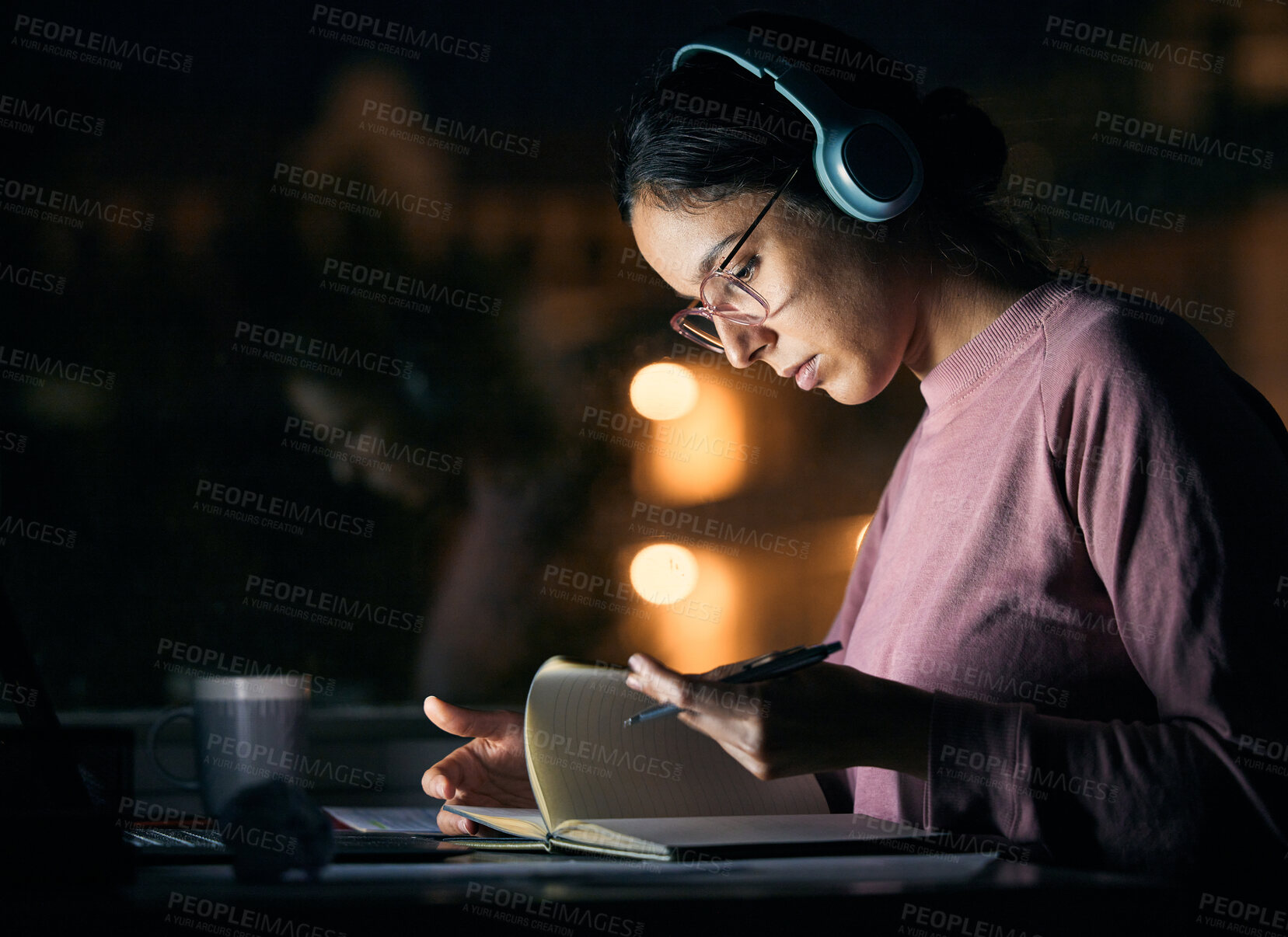 Buy stock photo Headphones, research and girl student studying at night for a test, exam or college assignment. University, notes and woman reading while listening to music, radio or podcast in the evening at a desk
