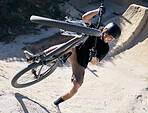 Man, bike and sport trick in the dunes for fitness, parkour or cycling workout in nature outdoors. Male cyclist or biker in sports training, exercise or competition on safari dirt track with bicycle