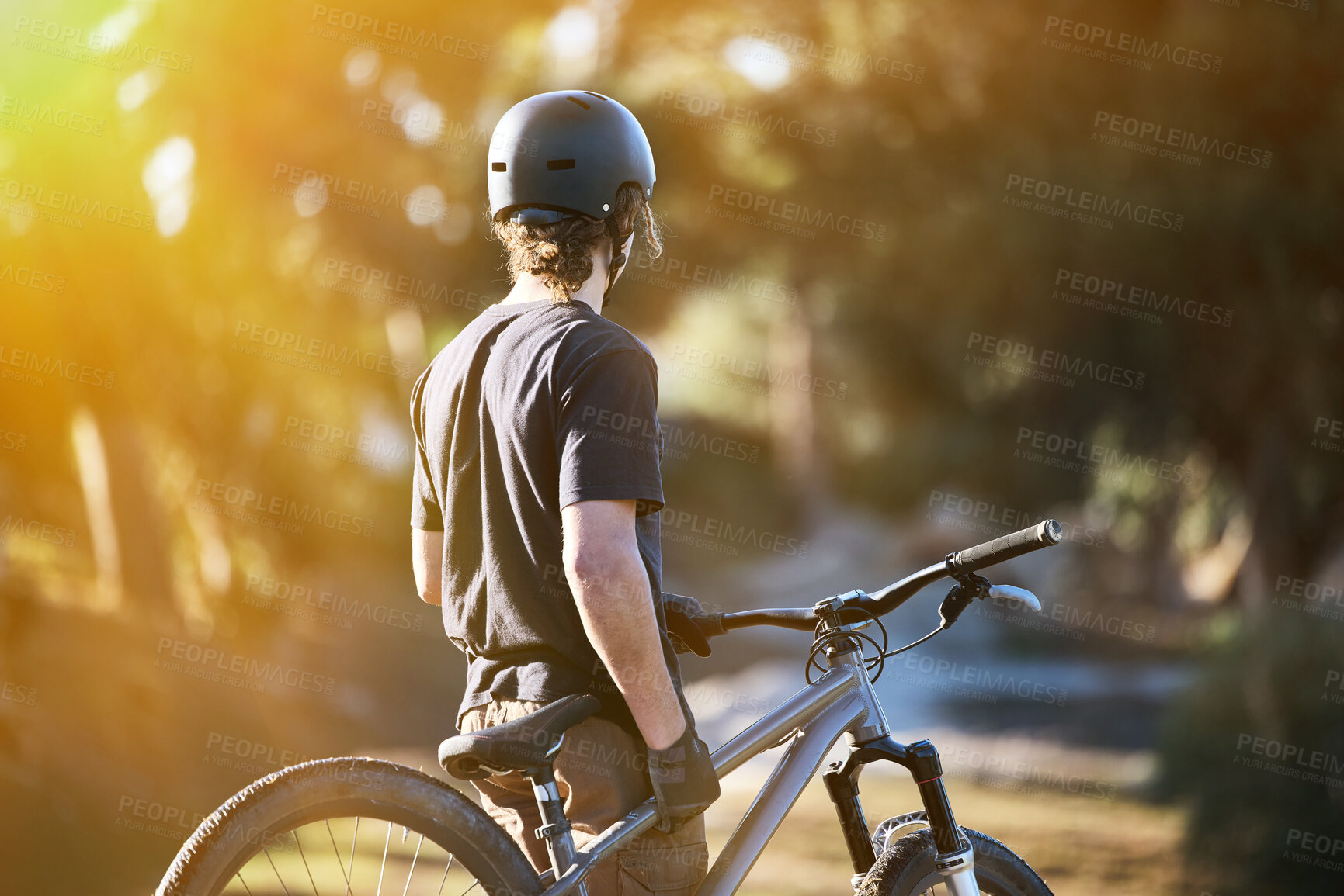 Buy stock photo Bike, exercise and summer with a sports man outdoor in nature for leisure or recreation in summer. Back, bicycle and fitness with a male athlete standing on an open green field carrying his transport