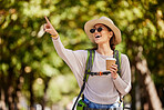 Woman, backpack or pointing in nature travel, sightseeing park or bird watching adventure in trees forest or Canada woods. Smile, happy tourist and showing hand gesture in hiking location with coffee