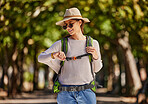 Woman, backpack and checking watch in nature travel, sightseeing or adventure in park, trees forest or Canada woods. Smile, happy and tourist on time clock for gps, location map or hiking technology