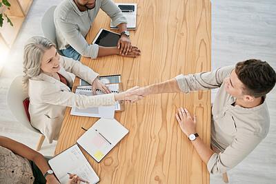 Buy stock photo Top view, meeting and handshake of business people in office. Welcome, partnership and group of employees shaking hands for contract, deal or agreement, hiring or recruitment, thank you or support.