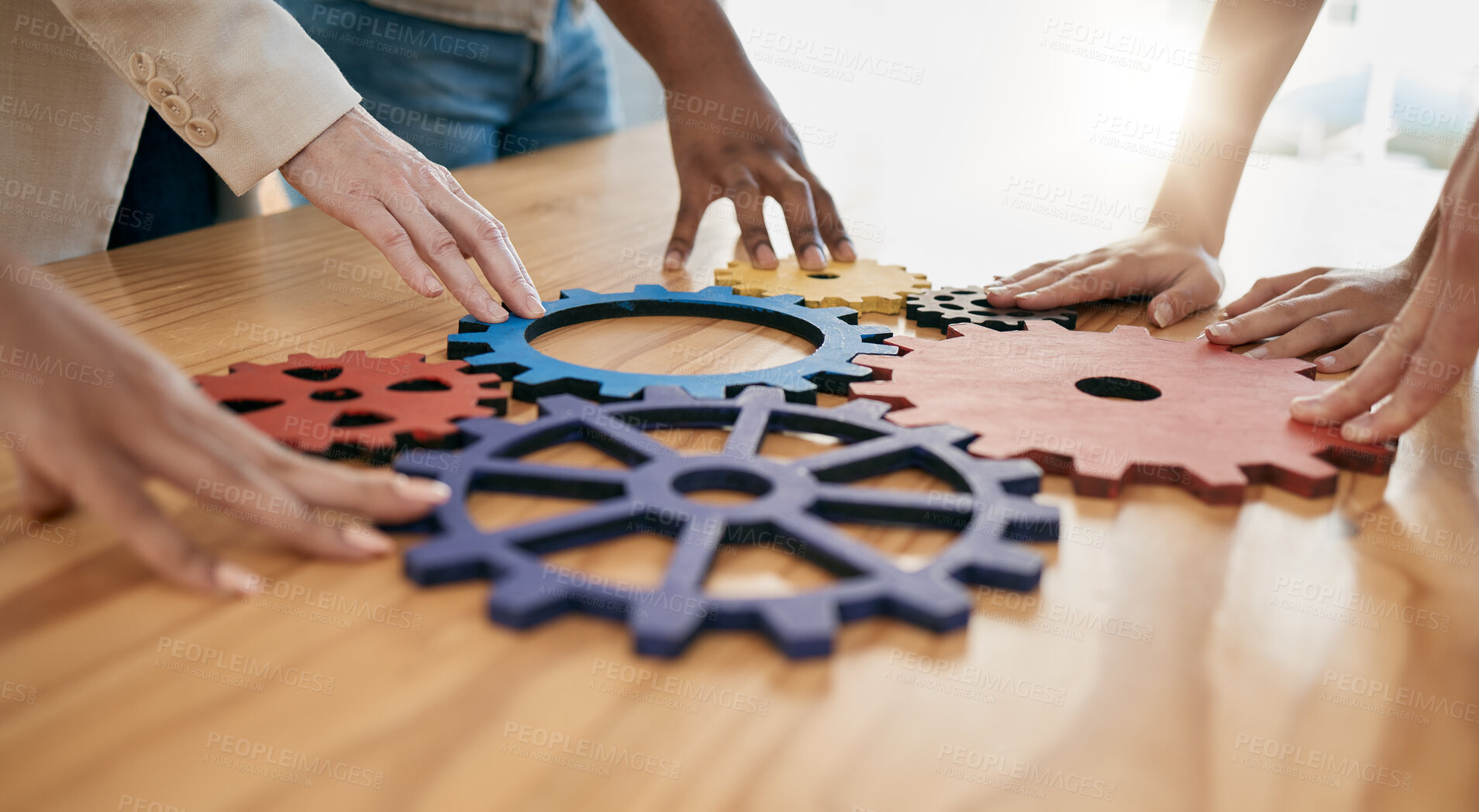 Buy stock photo Hands, collaboration and gear with a business team working together in synergy for innovation at a workshop. Meeting, teamwork and creative with a man and woman employee group at work in the office