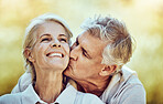 Senior couple, kiss and cheek with smile for love, romance and embrace together in the nature outdoors. Happy elderly woman and man kissing face for romantic bonding or quality time in happiness