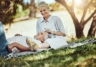 Buy stock photo Retirement, love and picnic with a senior couple outdoor in nature to relax on a green field of grass together. Happy, smile and date with a mature man and woman bonding outside for romance