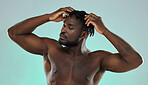 Dreadlocks hair, shirtless man and studio for beauty, self care and cosmetic wellness by blue background. African gen z model, muscle and strong body with hands on head, scalp massage and self love