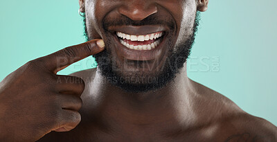 Buy stock photo Mouth, dental and teeth with a black man in studio on a blue background for oral hygiene at the dentist. Healthcare, insurance and whitening with a male touching his face or cheek for health