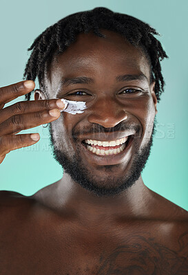 Buy stock photo Skincare, wellness and black man with face cream in a studio with a beauty, health and natural skin routine. Portrait, cosmetic and African guy with facial spf, lotion or creme by a blue background.