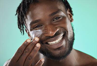 Buy stock photo Skincare, face cream and portrait of a black man in a studio with a beauty, health and natural skin routine. Wellness, cosmetic and African guy with facial spf, lotion or creme by a blue background.