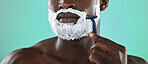 Black man, shaving and cream in studio for skincare, razor and facial cosmetics for beauty by blue background. African gen z model, hair removal foam or shave for aesthetic, cleaning or face grooming