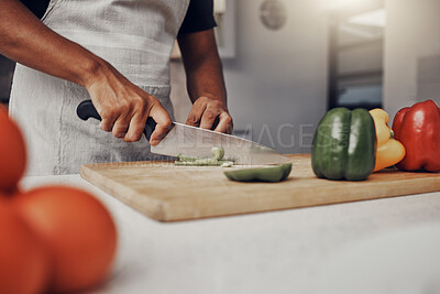 Buy stock photo Hands, food and cooking with a man in the kitchen, cutting a green pepper on a wooden chopping board. Salad, health and diet with a male chef preparing a meal while standing alone in his home