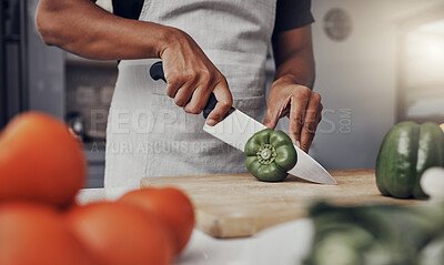 Buy stock photo Hands, food and cooking with a man cutting a green pepper in the kitchen on a wooden chopping board. Salad, health and diet with a male chef preparing a meal while standing alone in his home