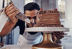 Piping, chef and man baker baking a cake with chocolate in a kitchen or pastry cook preparing a sweet recipe. Food, dessert and cook preparing a sweet meal in Brazil and adds cream or icing