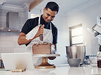 Piping, decorating and man baking a cake with chocolate in a kitchen or pastry chef happy with online recipe. Food, desert and cook preparing a sweet meal in Brazil and using a tablet