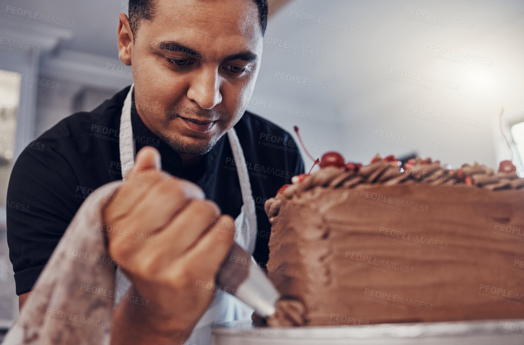 Buy stock photo Piping, kitchen and man baking a cake with chocolate or pastry chef preparing a recipe at a bakery. Food, dessert and professional baker making a sweet meal and adds cream or icing