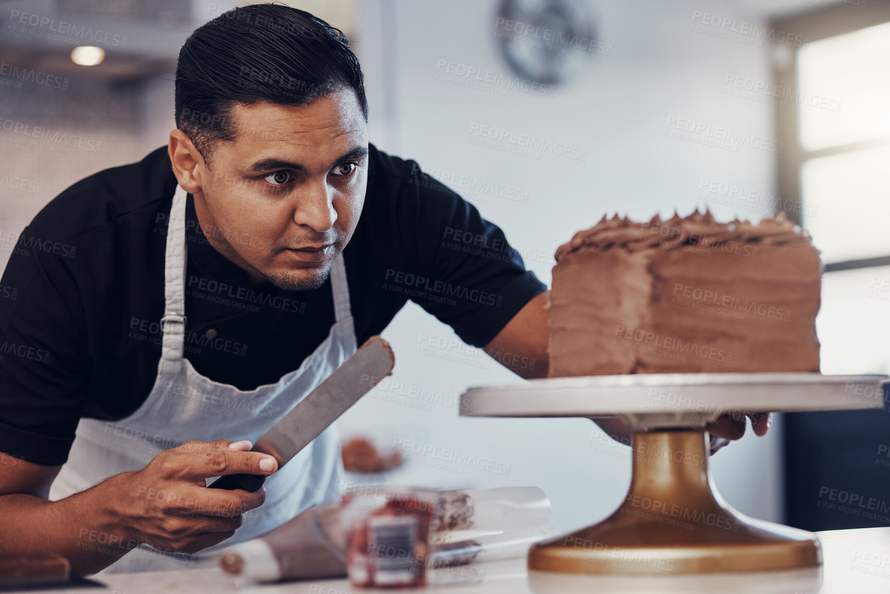 Buy stock photo Baking, kitchen and man icing cake with chocolate frosting and piping bag in bakery with focus and skill. Sweets, small business and baker decorating dessert for birthday event and working from home.