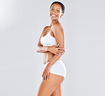 Black woman, healthy body and standing isolated on grey background with smile in underwear for skincare. Portrait of happy African American female smiling in happiness for perfect skin in lingerie